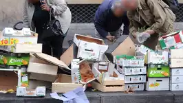 Personnes fouillant dans une poubelle en France, illustrant la précarité croissante.