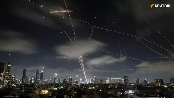 Ciel nocturne au-dessus d’une ville avec des traînées de missiles et de défense anti-aérienne