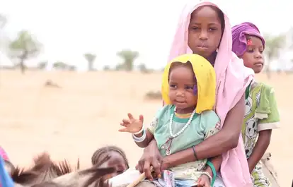 Enfants soudanais dans un paysage désertique, symbole de la crise humanitaire