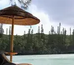 Transat vide face à une plage tropicale, symbole d’inaccessibilité des vacances