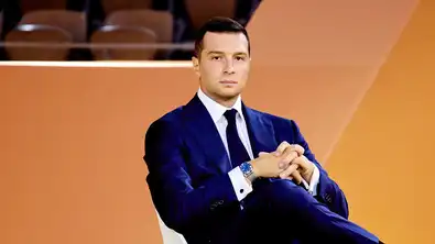 Un responsable politique français assis, symbole de la montée du RN dans les intentions de vote.