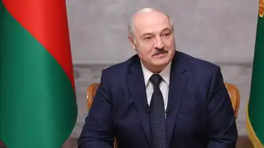 Alexandre Loukachenko lors d’une allocution officielle, drapeau biélorusse en arrière-plan