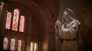 Statue d’un prieur en prière dans une église en France, symbole du renouvellement avec des prêtres venus d’Afrique