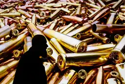 Silhouette sur fond de douilles d’armes illustrant les trafics liés aux conflits en Ukraine et au Soudan