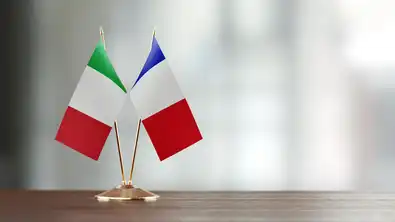 Drapeaux de l'Italie et de la France côte à côte sur une table en bois