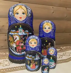Série de poupées russes matriochkas peintes à la main, posées sur une nappe traditionnelle.