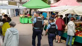 Gendarmes patrouillant sur un marché français, symbole de leur présence quotidienne et des agressions croissantes contre eux.