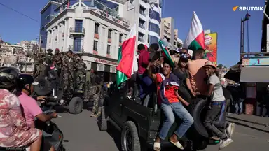 Des soldats et des civils brandissant des drapeaux malgaches lors de la prise de pouvoir de l’armée à Antananarivo.