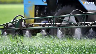 Pulvérisation de pesticides sur un champ, illustrant les exportations de produits interdits de l’UE vers l’Afrique.