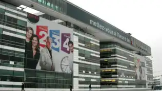 Façade du siège de France Télévisions à Paris avec des affiches de programmes télévisés.