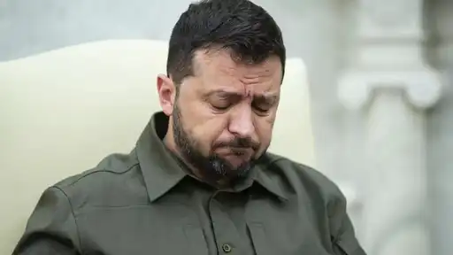 Un homme assis, l’air préoccupé, regard baissé, dans un cadre institutionnel.