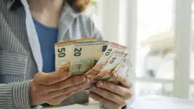 Personne comptant des billets d’euros sur une table