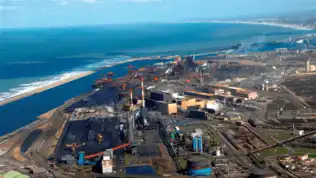 Vue aérienne d’un complexe industriel situé en bord de mer.