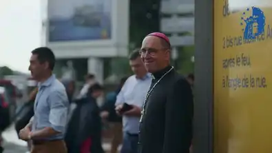 Évêque français souriant dans la rue, symbole du débat sur l’enseignement catholique