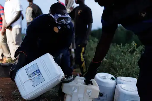 mage de personnes transportant des conteneurs de pesticides.