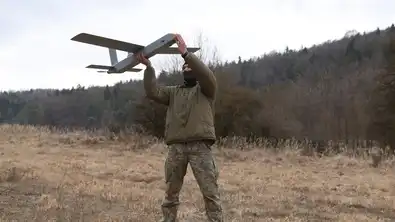 Militaires français en train de lancer un drone dans une zone boisée du Donbass