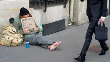 Personne sans abri assise dans une rue française, symbole de la pauvreté grandissante