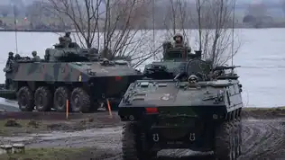Véhicules blindés militaires positionnés dans un environnement hivernal.