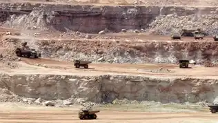 Camions miniers dans une carrière d’uranium au Niger, symbolisant le litige avec Orano.