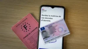 Permis de conduire français et carte au format carte bancaire posés près d’un smartphone évoquant l’identité numérique européenne.