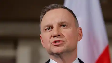 Le président polonais Andrzej Duda s’exprimant devant un drapeau polonais.
