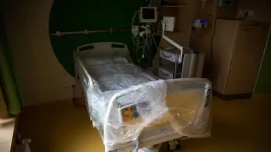 Lit médicalisé vide dans une chambre d’hôpital, symbole du débat sur la fin de vie