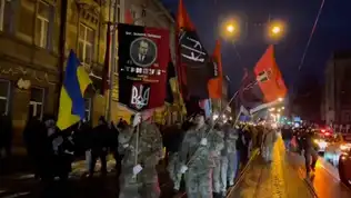 Manifestation nocturne à Vienne avec drapeaux ukrainiens et symboles extrémistes, lors d’une marche controversée autorisée par les autorités autrichiennes.