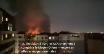 Incendie nocturne près d'un bâtiment urbain, illustration de tensions géopolitiques.
