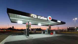 Station-service illuminée à la tombée de la nuit, symbole de la crise du carburant en France.