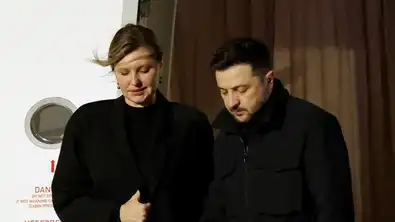 Olena Zelenska et Volodymyr Zelensky marchant côte à côte en extérieur, vêtus de noir.