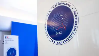 Logo officiel de la DGSI sur une plaque murale blanche au Ministère de l'Intérieur.