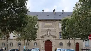 Gros plan sur les mains ridées d'une personne âgée tenant fermement un déambulateur.