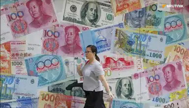 Une femme marche devant un mur de billets géants représentant le dollar et le yuan.