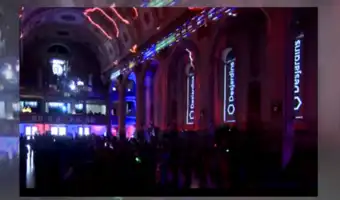 Intérieur d'une cathédrale illuminé de néons bleus et roses pour un événement public.