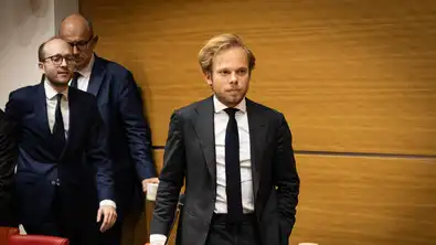 Le député Alexandre Alloncle marchant dans une salle de conférence à l'Assemblée nationale.