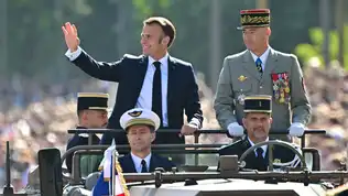 Emmanuel Macron saluant la foule depuis un véhicule militaire lors du défilé du 14 juillet.