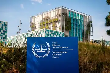 Bâtiment moderne de la Cour pénale internationale avec logo officiel au premier plan.