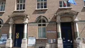 Manifestation d'agents périscolaires à Paris avec des banderoles devant un bâtiment officiel.
