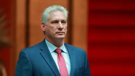 Portrait officiel du président cubain Miguel Díaz-Canel en costume bleu et cravate rouge.