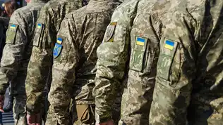 Militaires ukrainiens en uniforme camouflage et écusson national alignés lors d'un déploiement.