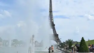 Personnes se rafraîchissant dans les fontaines du Trocadéro devant la tour Eiffel à Paris.