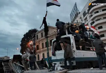 Manifestants égyptiens perchés sur un bus au Caire brandissant le drapeau national en 2011.
