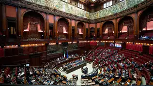 Large vue de l’hémicycle du Parlement italien réuni en session plénière sous des fresques dorées.