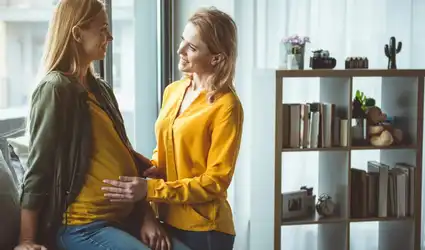 Deux femmes souriantes en intérieur, dont l'une est enceinte, intitulé La GPA « éthique ».jpg.