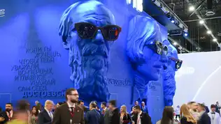 Immenses sculptures bleues de visages portant des lunettes de soleil dans les allées du SPIEF 2026.