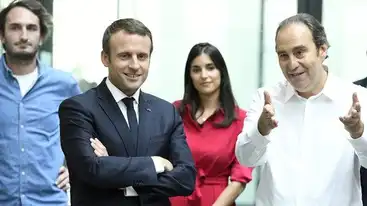 Emmanuel Macron souriant, bras croisés en costume, aux côtés de Xavier Niel gesticulant en chemise blanche et deux proches.