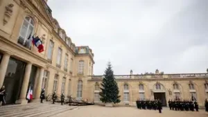 Façade du Palais de l'Élysée avec drapeau français et garde républicaine alignée.