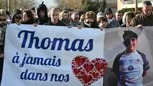 Manifestants tenant une grande banderole d'hommage au jeune Thomas avec sa photo et un cœur rouge.