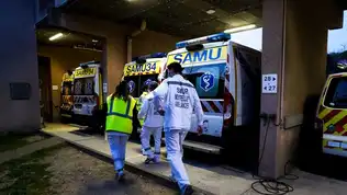 Ambulanciers en uniforme marchant près de véhicules du SAMU et du SMUR de nuit.