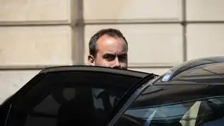 Sébastien Lecornu aperçu à la portière de sa voiture officielle devant un bâtiment.